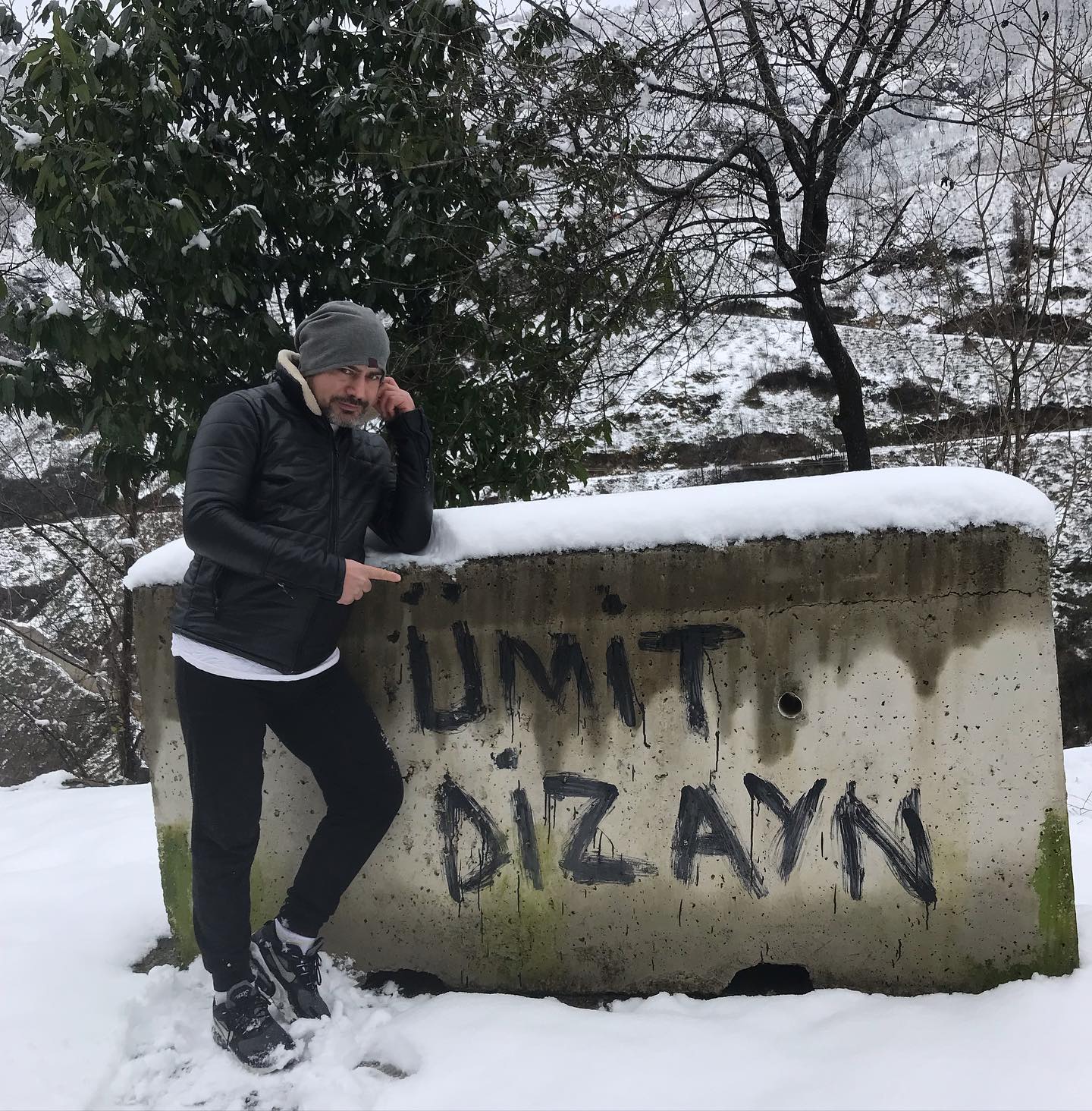 Interior designer Ümit Hava posing in front of a wall he tagged in a park in Istanbul.
